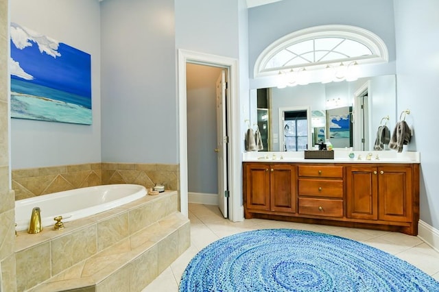 bathroom with tile patterned flooring, vanity, and tiled bath