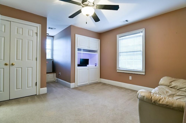 sitting room featuring light carpet and ceiling fan