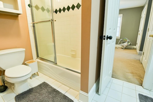 bathroom with bath / shower combo with glass door, tile patterned floors, and toilet