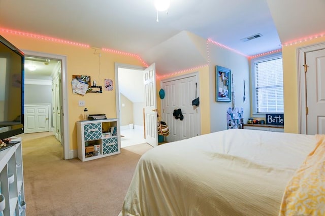 bedroom with a closet, lofted ceiling, light carpet, and ornamental molding