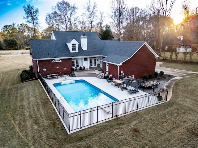 view of pool with french doors, a yard, and a patio area