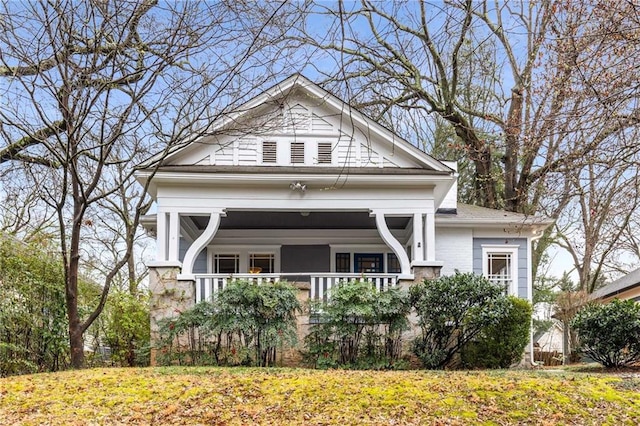 view of front facade featuring brick siding, covered porch, and a front lawn