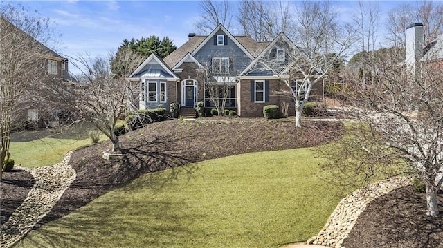 view of front facade with brick siding and a front yard