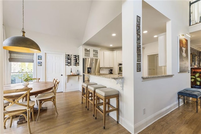 dining space with recessed lighting, baseboards, and wood finished floors