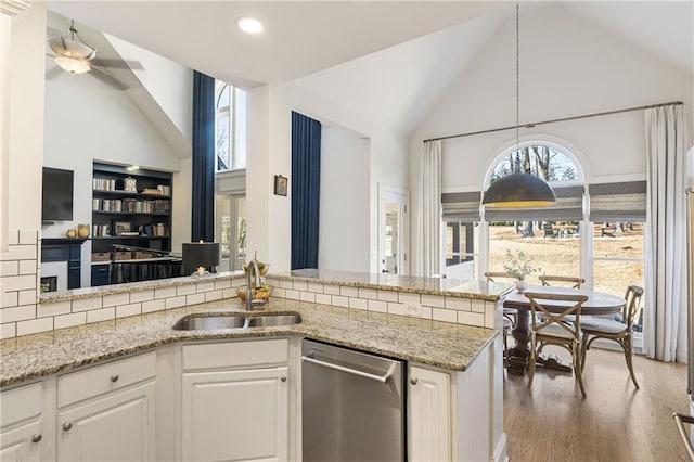 kitchen featuring a sink, white cabinets, wood finished floors, and stainless steel dishwasher