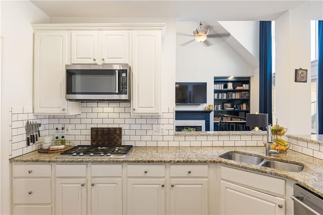 kitchen with decorative backsplash, appliances with stainless steel finishes, white cabinetry, and a sink