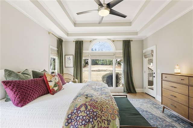 bedroom featuring a ceiling fan, light wood-style floors, crown molding, a raised ceiling, and access to exterior