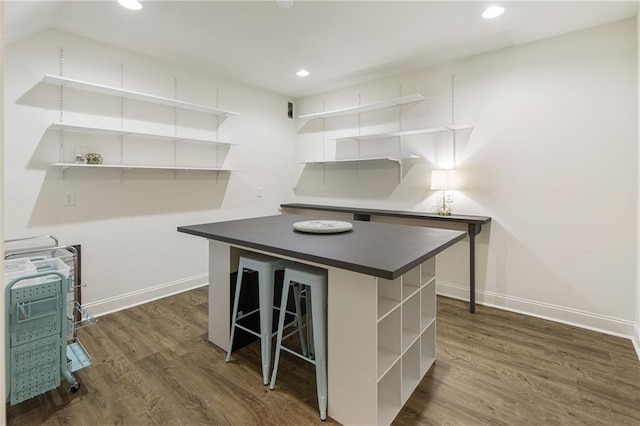 kitchen featuring dark wood-style floors, baseboards, a kitchen island, open shelves, and dark countertops