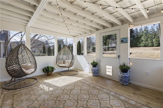 unfurnished sunroom featuring beam ceiling and a wealth of natural light