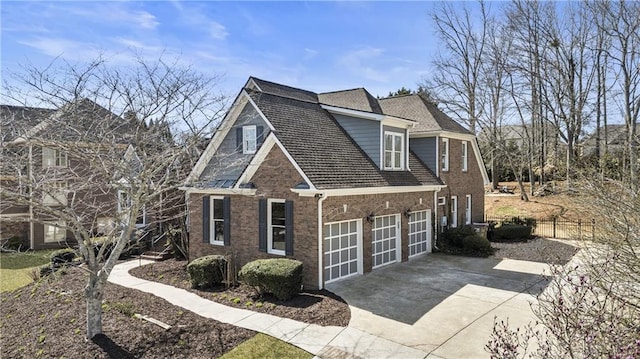 view of property exterior with a garage, brick siding, driveway, and fence