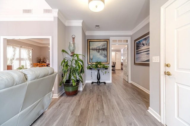 hall with light hardwood / wood-style flooring and ornamental molding