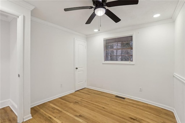 empty room featuring visible vents, baseboards, light wood-style flooring, ceiling fan, and crown molding