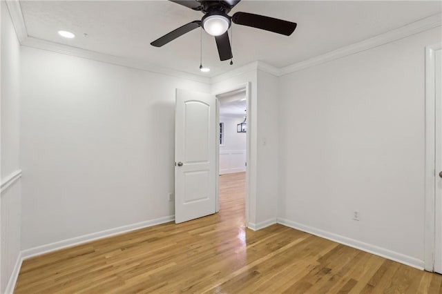 spare room featuring a ceiling fan, recessed lighting, light wood-style floors, crown molding, and baseboards