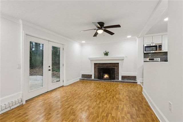 unfurnished living room featuring crown molding, baseboards, light wood-type flooring, and ceiling fan