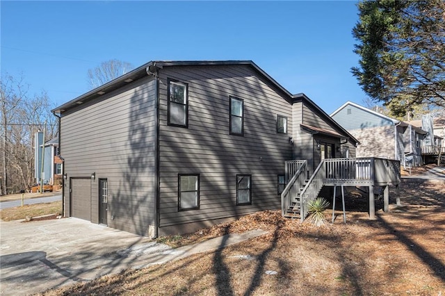 rear view of property with a garage and a deck