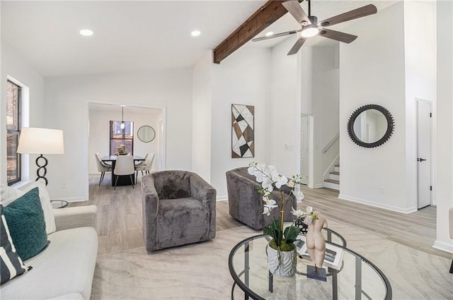 living room featuring lofted ceiling with beams, light hardwood / wood-style floors, and a wealth of natural light