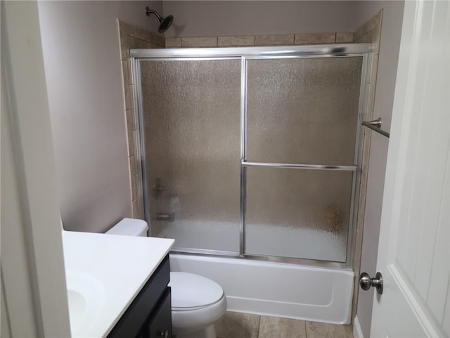 full bathroom featuring tile floors, toilet, enclosed tub / shower combo, and vanity