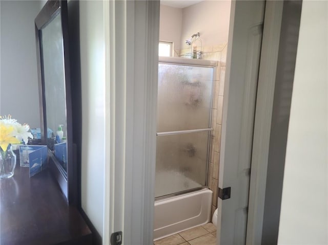 bathroom with enclosed tub / shower combo and tile flooring