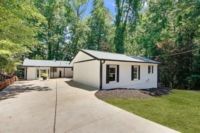 view of front of home featuring concrete driveway and a front lawn