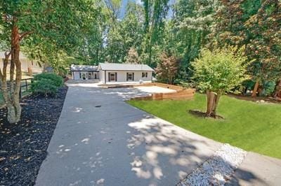 ranch-style house with a front yard, driveway, and fence