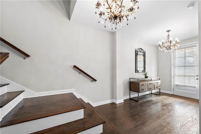 staircase featuring a notable chandelier, baseboards, and wood finished floors