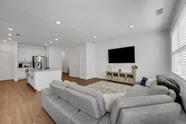 living room featuring ornamental molding and light hardwood / wood-style flooring