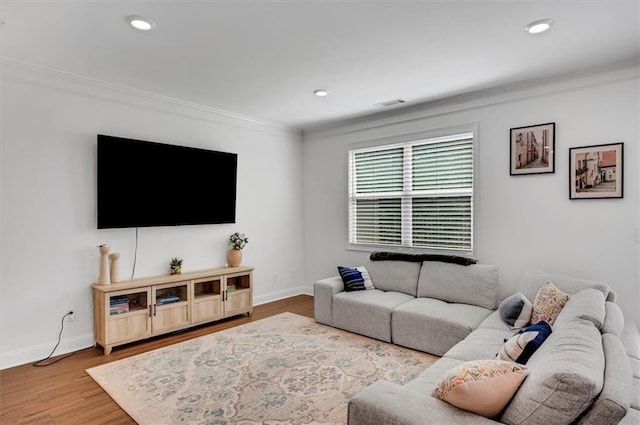 living room with hardwood / wood-style flooring and ornamental molding