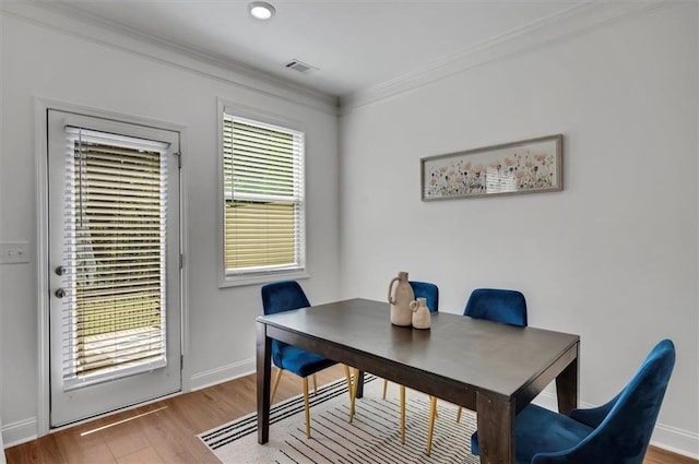 dining area with crown molding and wood-type flooring