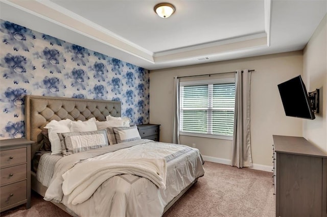 bedroom with crown molding, a tray ceiling, and light carpet