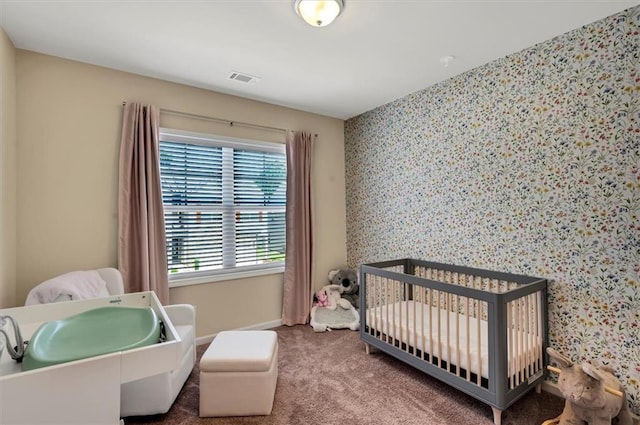 bedroom featuring a nursery area and carpet