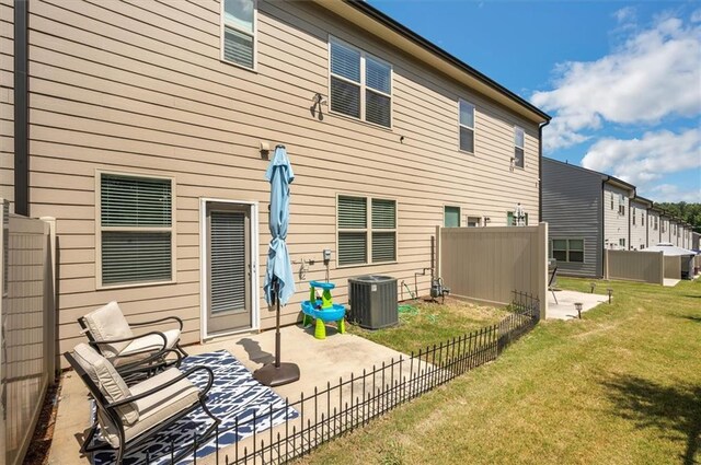 rear view of property with central AC, a yard, and a patio area