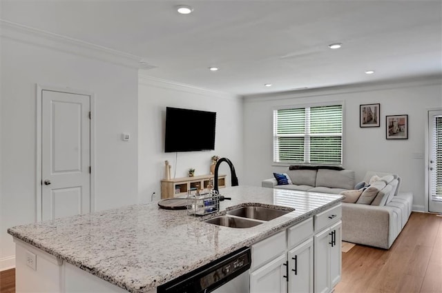 kitchen with dishwasher, an island with sink, sink, white cabinets, and light stone counters