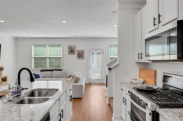 kitchen featuring stainless steel appliances, light stone countertops, and sink