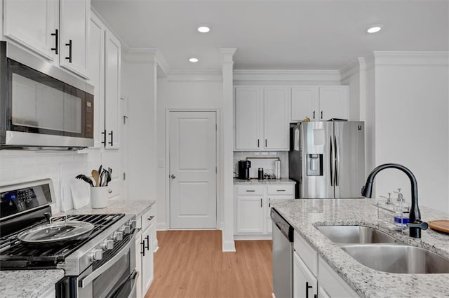 kitchen featuring appliances with stainless steel finishes, sink, and white cabinets