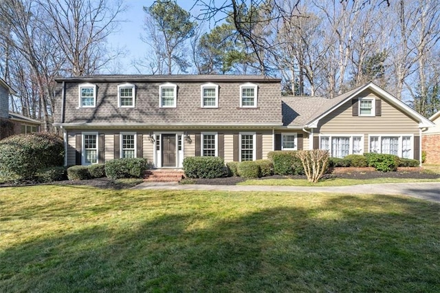 view of front of property with a shingled roof and a front lawn