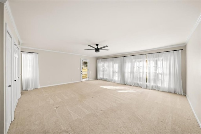 spare room with light carpet, baseboards, ornamental molding, and ceiling fan