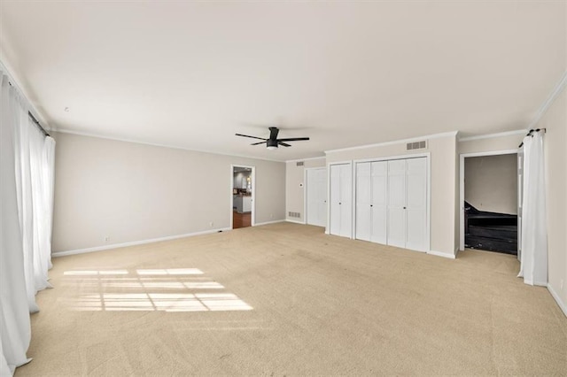 unfurnished bedroom featuring baseboards, ornamental molding, visible vents, and light colored carpet