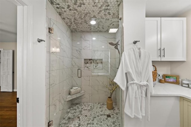 bathroom featuring wood finished floors and a shower stall