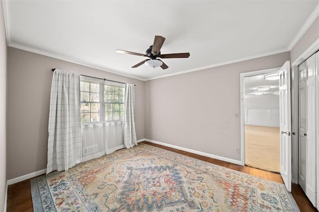 bedroom with ornamental molding, wood finished floors, visible vents, and baseboards