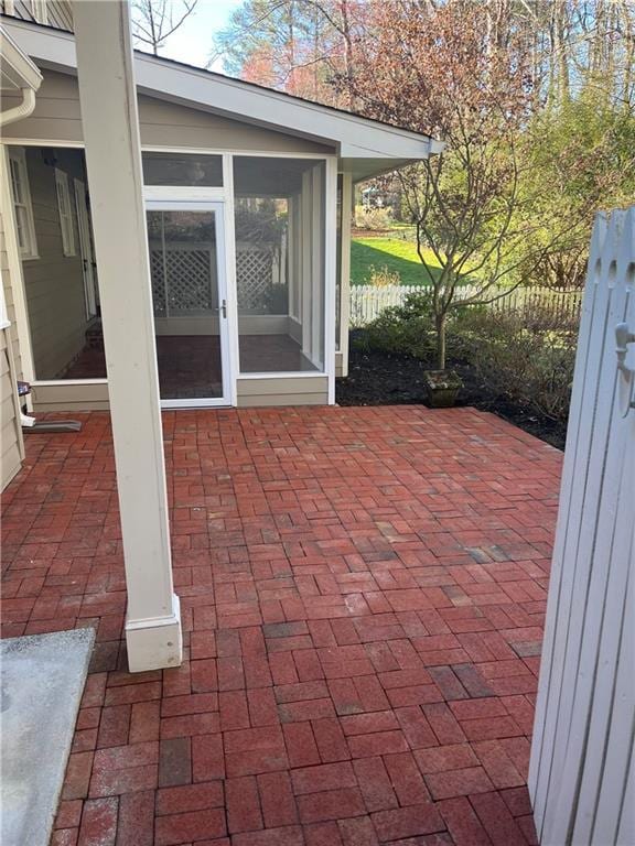 view of patio / terrace with a sunroom and fence