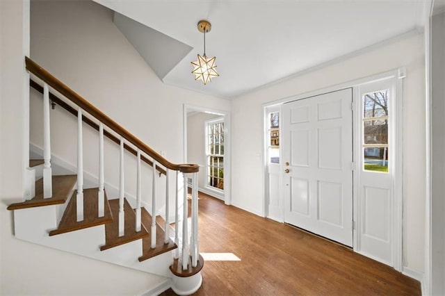 foyer entrance featuring plenty of natural light, stairs, and wood finished floors