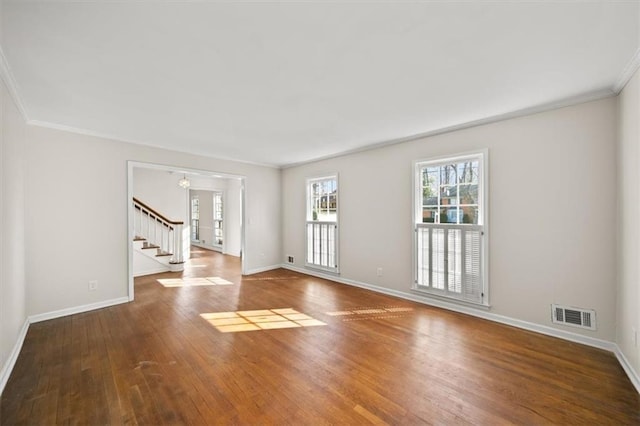 spare room with baseboards, stairs, visible vents, and wood finished floors