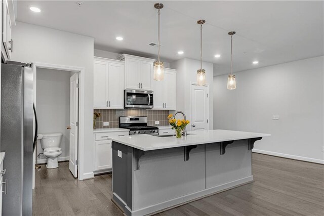 355 Niles Ct Unit 2, Marietta, GA 30060 - kitchen with a kitchen breakfast bar, dark wood-style floors, light countertops, a sink, and appliances with stainless steel finishes