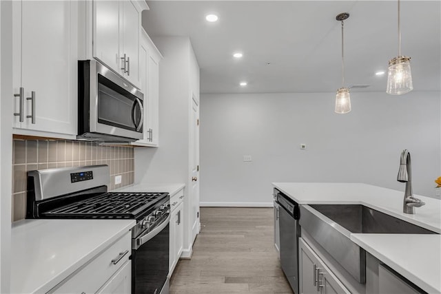 355 Niles Ct Unit 2, Marietta, GA 30060 - kitchen featuring backsplash, hanging light fixtures, a sink, light wood-style floors, and stainless steel appliances
