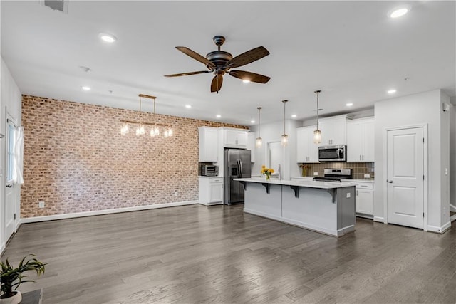 355 Niles Ct Unit 2, Marietta, GA 30060 - kitchen with a breakfast bar area, ceiling fan, light countertops, white cabinets, and stainless steel appliances