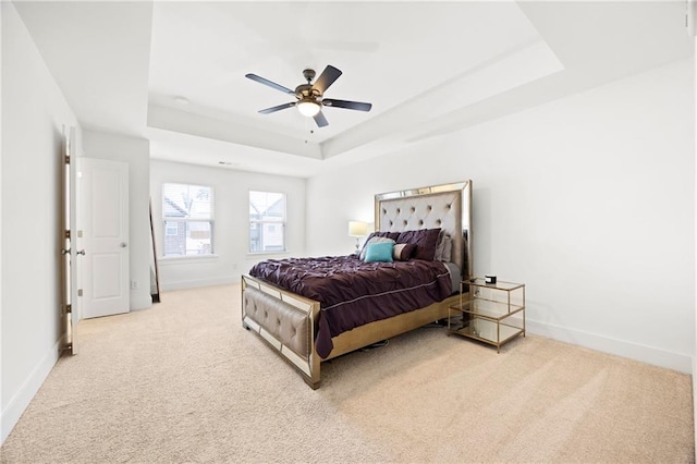 bedroom featuring a tray ceiling, ceiling fan, and light colored carpet