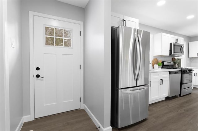 kitchen featuring dark wood-type flooring, white cabinets, and stainless steel appliances