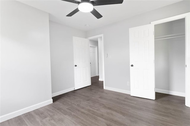 unfurnished bedroom featuring ceiling fan, a closet, and dark hardwood / wood-style flooring