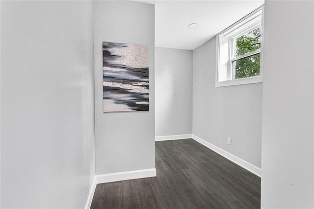 unfurnished room with dark wood-type flooring