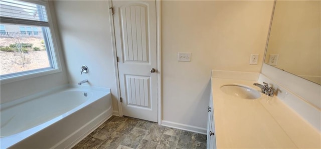 bathroom featuring a washtub and vanity